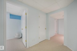 Wall-to-wall carpeting throughout, multiple white panel doors, and a drop ceiling - 