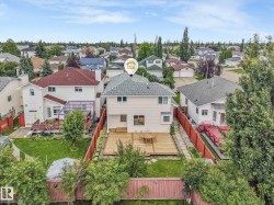 Rear exterior showcasing a wood deck, fenced backyard, and mature trees - 