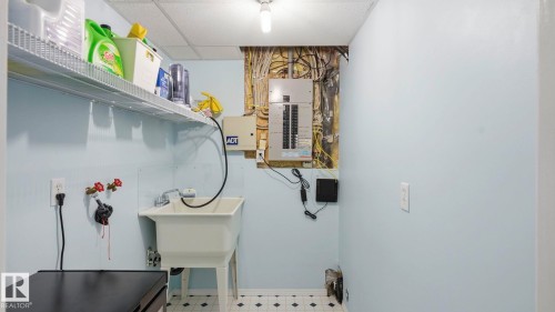 Utility room featuring a laundry sink, wire shelving, and light blue wall paint - 1225 Kane Wynd, Edmonton, AB 