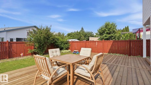 Spacious wooden deck extending to a grassy yard, enclosed by a privacy fence - 1225 Kane Wynd, Edmonton, AB 