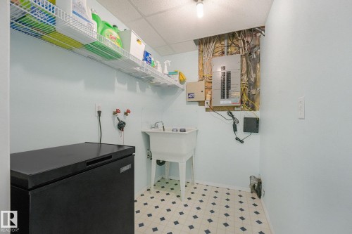 Utility sink, wire shelving, circuit breaker panel, and patterned floor tiles - 1225 Kane Wynd Nw, Edmonton, AB - Indoor