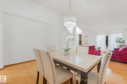 Hardwood flooring, crystal chandelier, and white wall finishes - 