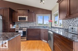 Kitchen featuring wood-finish flooring, dark wood cabinetry, and stainless steel appliances - 