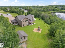 Spacious property featuring a two-story residence with an attached garage, a detached shed, and an expansive lawn - 