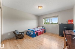 Spacious room featuring light wood-finish flooring, neutral wall paint, a single window with a white frame, and a flush-mount ceiling light fixture - 