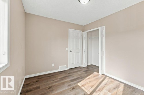 Room featuring wood-finish flooring, neutral wall paint, and white trim - 2811 33 Street, Edmonton, AB 