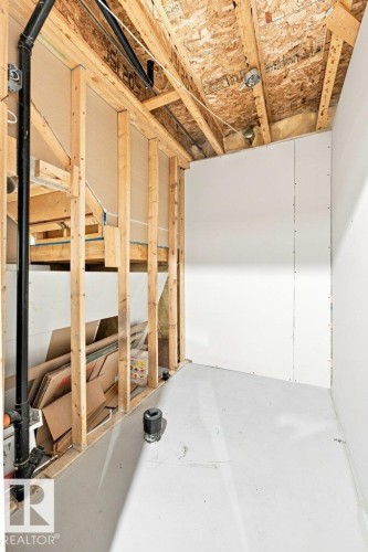 Partially finished basement space featuring exposed wooden framing, visible overhead joists, and installed drywall sections - 2811 33 Street, Edmonton, AB 