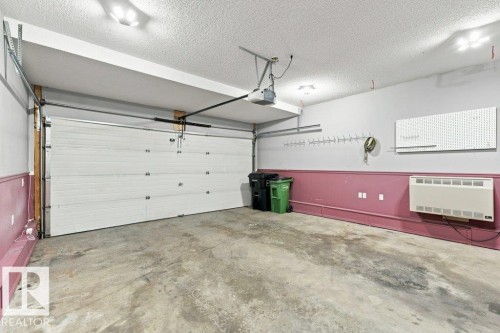 Spacious garage featuring a concrete floor, overhead lighting, and an automatic garage door opener - 2811 33 Street, Edmonton, AB 
