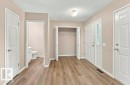 Entryway featuring wood-finish flooring, a double-door entry with a sidelight, and a built-in coat closet with bi-fold doors - 2811 33 Street, Edmonton, AB 