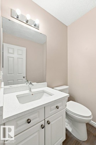 Bathroom vanity featuring a white cabinetry, light-colored countertop, and integrated sink - 2811 33 Street, Edmonton, AB 
