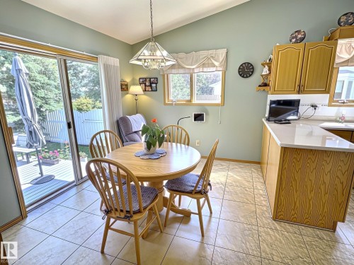 Eat-in kitchen featuring wood-finish cabinetry, light-toned countertops, and tile flooring - 171 Rhatigan Road, Edmonton, AB 