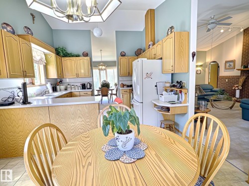 Eat-in kitchen featuring light wood cabinetry, white countertops, and tile flooring - 171 Rhatigan Road, Edmonton, AB 