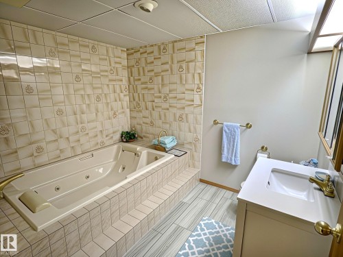 Spacious bathroom featuring a built-in jetted tub surrounded by decorative tilework - 171 Rhatigan Road, Edmonton, AB 