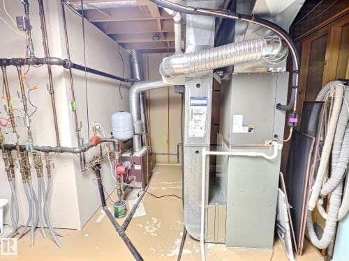Utility room featuring a forced air unit, exposed ductwork, and a comprehensive plumbing manifold system - 171 Rhatigan Road, Edmonton, AB 