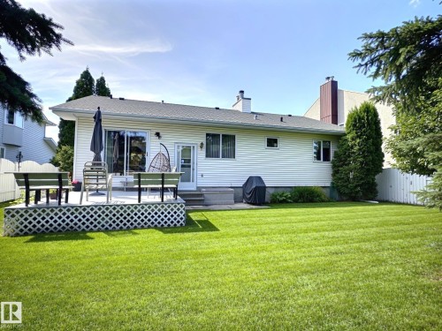 Expansive green lawn with a white lattice-skirted deck - 171 Rhatigan Road, Edmonton, AB 