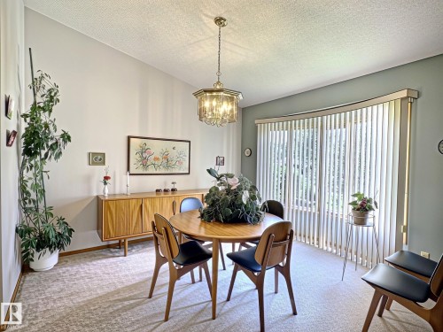 Dining area featuring a vaulted ceiling and a crystal chandelier - 171 Rhatigan Road, Edmonton, AB 