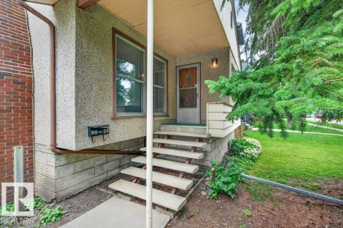 Front exterior with textured stucco siding and brick chimney - 9026 92 Street Nw, Edmonton, AB - Outdoor
