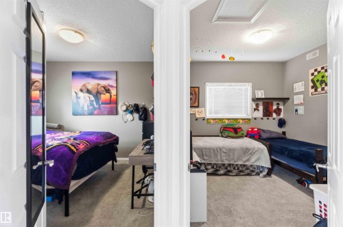 Two distinct bedrooms featuring neutral wall tones, carpeted flooring, and flush-mount ceiling lighting - 24 6520 2 Avenue, Edmonton, AB 