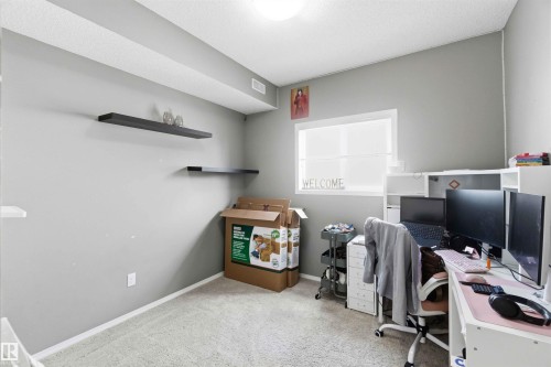 Carpeted room with light grey walls and a single window - 24 6520 2 Avenue, Edmonton, AB 