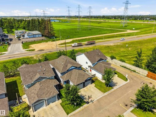 Residential community featuring multiple detached homes with attached garages, shingle roofs, and paved driveways - 24 6520 2 Avenue, Edmonton, AB 
