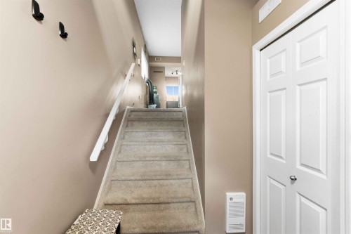 Carpeted staircase with white handrail and neutral wall color - 24 6520 2 Avenue, Edmonton, AB 