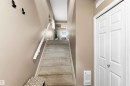 Carpeted staircase with white handrail and neutral wall color - 24 6520 2 Avenue, Edmonton, AB 