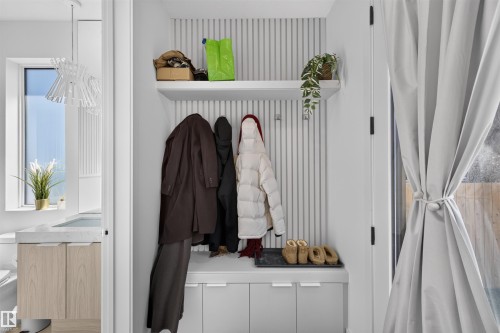 Built-in entryway storage with slatted wall paneling, integrated shelving, and lower cabinetry - 8551 81 Avenue, Edmonton, AB 