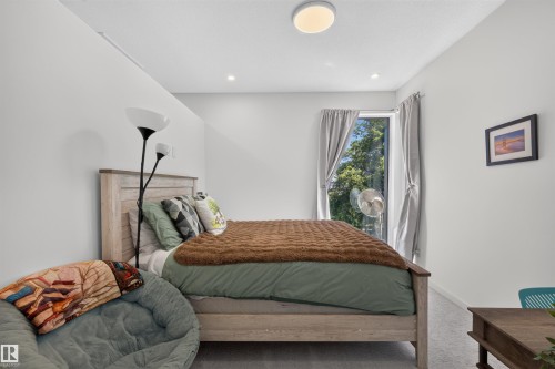 Bedroom featuring light gray wall paint, a window with gray drapes, and recessed ceiling lighting - 8551 81 Avenue, Edmonton, AB 