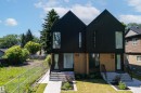 Contemporary duplex featuring a black facade with pitched roofs and wood-finish lower panels - 8551 81 Avenue, Edmonton, AB 