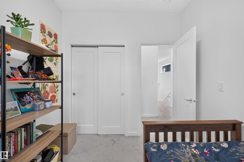 White interior walls with a built-in closet featuring two panel doors - 8551 81 Avenue, Edmonton, AB 