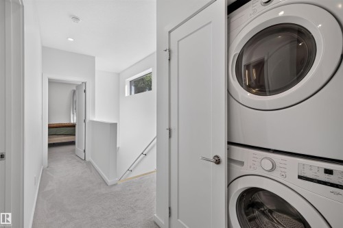 Integrated laundry closet featuring a stacked washer and dryer unit - 8551 81 Avenue, Edmonton, AB 