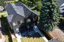 Modern exterior featuring dark vertical siding and a dark shingle roof - 8551 81 Avenue, Edmonton, AB 