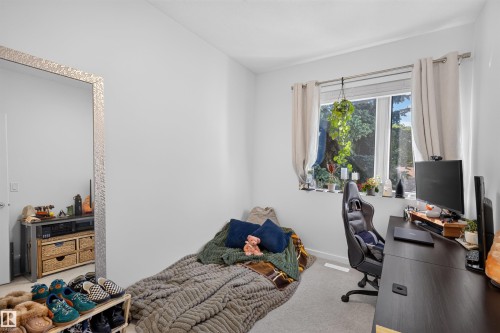 Bedroom featuring a window with natural light, neutral wall colors, and carpet flooring - 8551 81 Avenue, Edmonton, AB 