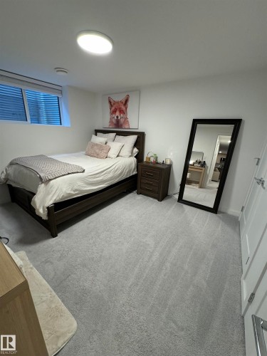 Bedroom featuring light gray carpet flooring and white walls - 8551 81 Avenue, Edmonton, AB 