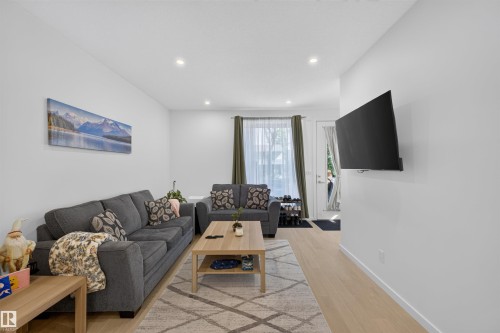 Living area featuring recessed lighting, light wood-finish flooring, and a white color palette - 8551 81 Avenue, Edmonton, AB 