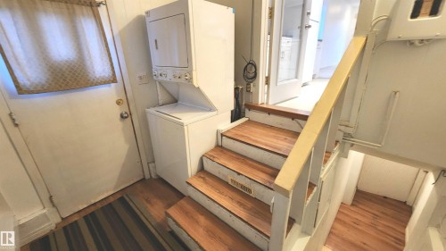 Wood-finish stair treads with white risers and railing - 9359 92 Street, Edmonton, AB 