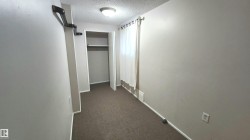 Room featuring wall-to-wall carpeting, neutral wall paint, and a built-in closet with shelving and hanging rod - 