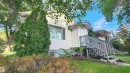 White siding exterior with a dark grey painted wood-finish deck and railings - 9359 92 Street, Edmonton, AB 