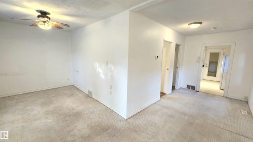 Expansive interior space featuring carpet flooring and white painted walls - 9359 92 Street, Edmonton, AB 