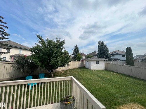 Expansive backyard featuring a manicured lawn, established trees, and perimeter fencing - 1417 115A Street, Edmonton, AB - Outdoor With Backyard