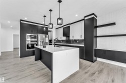 Contemporary kitchen featuring a white quartz island with an undermount sink and matte black faucet - 