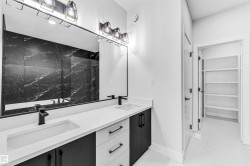 Dual vanity featuring integrated sinks, white countertops, and black cabinetry with matte black hardware - 