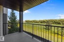Covered balcony featuring a concrete floor and black metal railing - 4615 199 Street, Edmonton, AB 