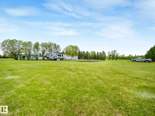 Expansive green lawn with a tree line in the background - 53133 Rge Road 223, Rural Strathcona County, AB - Outdoor With View