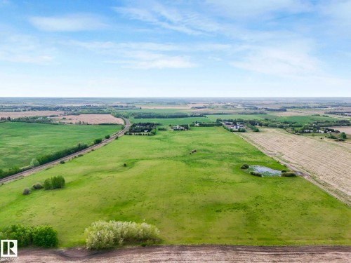 Expansive agricultural land featuring a verdant field, cultivated acreage, and natural wetland areas - 53133 Rge Road 223, Rural Strathcona County, AB - Outdoor With View