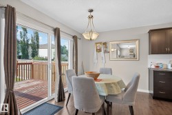 Dining area with wood-finish flooring and a central chandelier - 