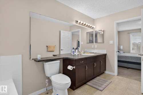 Bathroom featuring a dark wood-finish vanity with an integrated sink and ample storage - 7858 170A Avenue, Edmonton, AB 