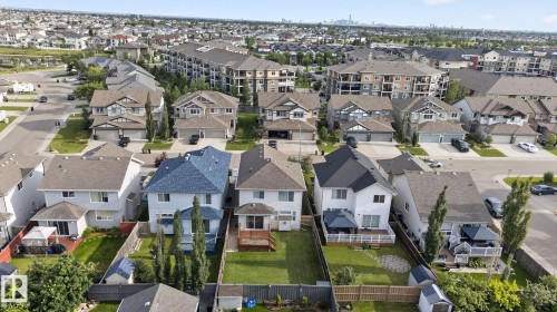 Aerial perspective showcasing a residential neighborhood with detached homes featuring various roof styles and private fenced backyards - 7858 170A Avenue, Edmonton, AB 