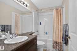 Bathroom featuring a dark wood vanity with an integrated oval sink, a speckled countertop, and a vanity mirror - 