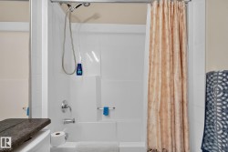 Alcove bathtub with white tile surround and integrated shelving - 